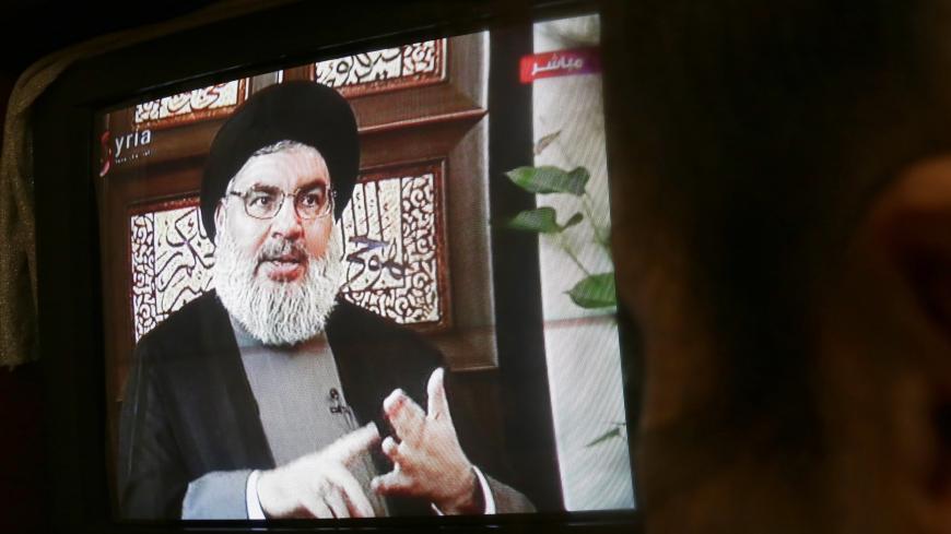A Syrian watches an interview of Hassan Nasrallah, the head of Lebanon's militant Shiite Muslim movement Hezbollah, screened on Syria's official television channel Al-Ikhbariya on April 6, 2015 in Damascus. AFP PHOTO / STR (Photo credit should read -/AFP via Getty Images)