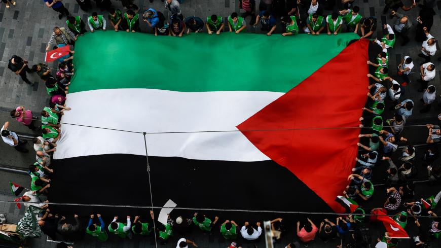 Demonstrators chant slogans as they march with a giant Palestinian flag on May 31, 2018 at Istiklal avenue in Istanbul, to mark the 8th anniversary of a deadly raid on Turkish-registered Mavi Marmara - part of a flotilla of six vessels seeking to break Israel's blockade and enter Gaza. - The crowd has gathered in iconic Istiklal avenue under the banner of the pro-Islamic Humanitarian Relief Foundation (IHH), one of the organisers of the flotilla that tried to break an Israeli sea blockade of the Hamas-contr