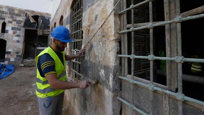 Workers restore a palatial Ottoman-era home called Beit al-Quwatli to turn it into a cultural institution in the old part of Syria's capital Damascus on November 10, 2020. - The old city of the Syrian capital is famed for its elegant century-old houses, usually two storeys built around a leafy rectangular courtyard with a carved stone fountain at its centre. While the capital has been largely spared the violence of Syria's almost ten-year war, several of these traditional homes have been abandoned by their