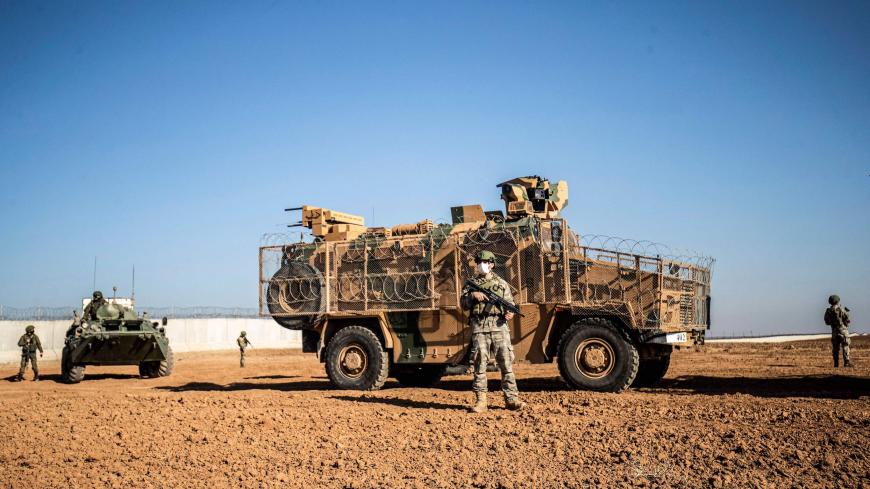 A Turkish soldier stands guard next to a military vehicle during a joint Russian-Turkish patrol in the eastern countryside of the town of Darbasiyah near the border with Turkey in Syria's northeastern Hasakah province on December 7, 2020. (Photo by Delil SOULEIMAN / AFP) (Photo by DELIL SOULEIMAN/AFP via Getty Images)