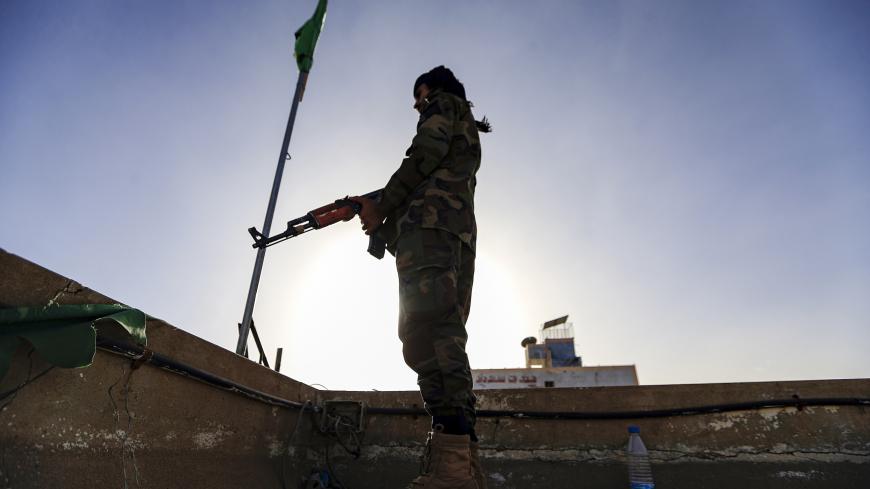 A member of security forces loyal to Yemen's Huthi rebels stands guard as supporters attend a rally denouncing the United States and the outgoing Trump administration's decision to apply the "terrorist" designation to the Iran-backed movement, in the Huthi-held capital Sanaa on January 25, 2021. (Photo by Mohammed HUWAIS / AFP) (Photo by MOHAMMED HUWAIS/AFP via Getty Images)
