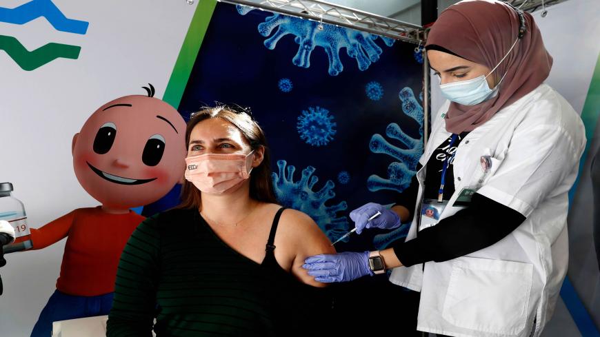 A health worker administers a dose of the Pfizer-BioNtech COVID-19 vaccine at Clalit Health Services, in a gymnasium in the Israeli city of Petah Tikva, on February 1, 2021. - Israel's nationwide lockdown was extended to contain the coronavirus which has continued to spread rapidly as the country presses ahead with an aggressive vaccination campaign. (Photo by JACK GUEZ / AFP) (Photo by JACK GUEZ/AFP via Getty Images)