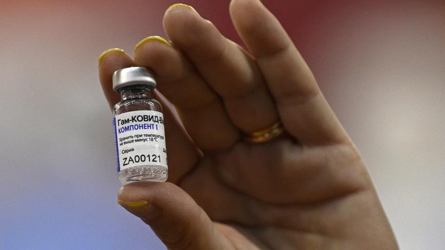 A health worker displays a vial of the Sputnik V vaccine against COVID-19, in a vaccination centre for medical health workers, at the basketball court of Argentine club River Plate, bellow the grandstand of the Monumental stadium, in Buenos Aires on February 2, 2020. (Photo by Juan MABROMATA / AFP) (Photo by JUAN MABROMATA/AFP via Getty Images)