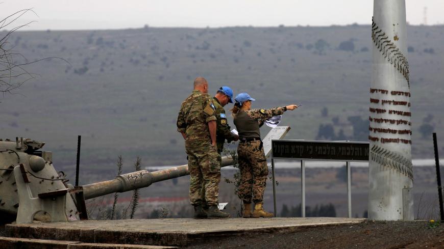 Memebers of the United Nations Disengagement Observer Force (UNDOF) stand near an old Israeli tank as they look toward the Syrian governorate of Quneitra from the Israeli-annexed Golan Heights, on February 4, 2021. (Photo by JALAA MAREY / AFP) (Photo by JALAA MAREY/AFP via Getty Images)