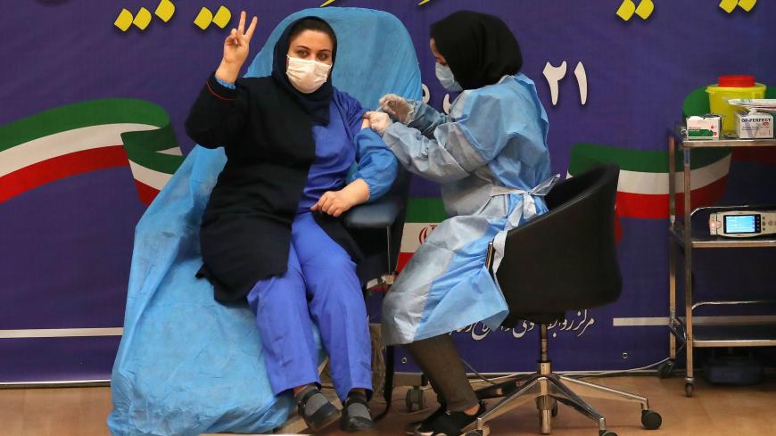 TOPSHOT - Iranian health worker Sara Gudarzi receives the COVID-19 vaccine as the country launches its inoculation campain, at the Imam Khomeini hospital in the capital Tehran, on February, 9, 2021. - The inoculation effort for 80-million-plus population is starting with Russia's Sputnik V vaccine, authorities have said, as the novel coronavirus has infected 1.4 million people in Iran and killed more than 58,500, according to the health ministry. (Photo by ATTA KENARE / AFP) (Photo by ATTA KENARE/AFP via Ge
