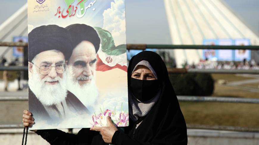 An Iranian woman holds a picture of Iranian supreme leader Ayatollah Ali Khamenei and former Iranian supreme leader Ayatollah Ruhollah Khomeini during a ceremony marking the 42nd anniversary of the 1979 Islamic Revolution, at the Azadi (Freedom) square in Tehran, on February 10 2021. (Photo by STR / AFP) (Photo by STR/AFP via Getty Images)