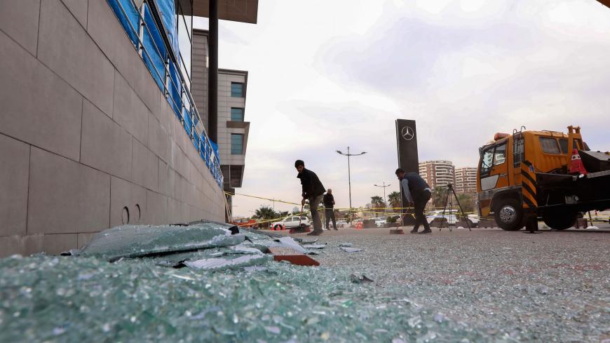 A worker cleans shattered glass on February 16, 2021 outside a damaged shop following a rocket attack the previous night in Arbil, the capital of the northern Iraqi Kurdish autonomous region. - The United Nations warned Tuesday Iraq could spin out of control after a rocket attack on the Kurdish regional capital Arbil killed a foreign contractor and wounded several Iraqis and foreigners. (Photo by SAFIN HAMED / AFP) (Photo by SAFIN HAMED/AFP via Getty Images)