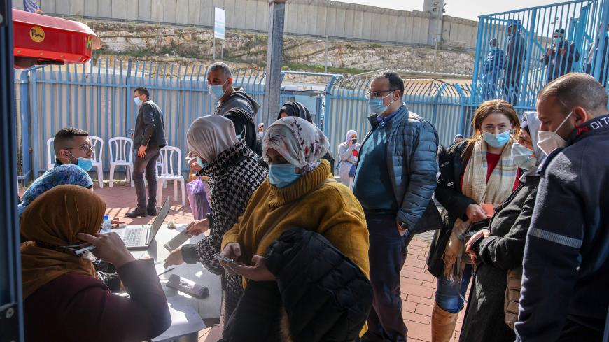 Palestinians wait to receive doses of the the Pfizer-BioNTech COVID-19 coronavirus vaccine provided by Israel's Magen David Adom medical services at Qalandia checkpoint on the crossing between the West Bank city of Ramallah and Israeli-annexed east Jerusalem, on February 23, 2021. - Israel said its "limited" supply of unused coronavirus vaccines would be sent to the Palestinians and several countries, with Honduras, which plans to move its embassy to Jerusalem, reportedly on the list. The world leader in va