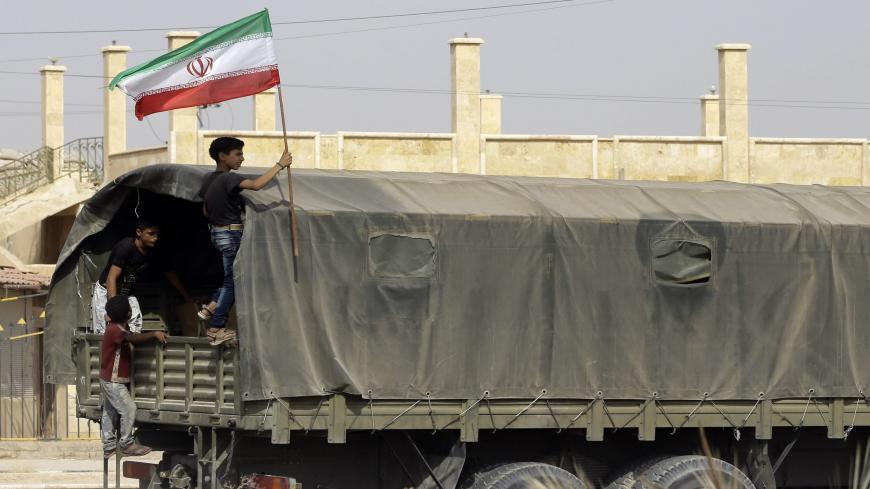 A Syrian boy holds the Iranian flag as a truck carrying aid provided by Iran arrives in the eastern city of Deir Ezzor on September 20, 2017 while Syrian government forces continue to press forward with Russian air cover in the offensive against Islamic State group jihadists across the province.
Two separate offensives are under way against the jihadists in the area -- one by the US-backed Syrian Democratic Forces, the other by Russian-backed government forces. The Syrian army now controls around 70 percent