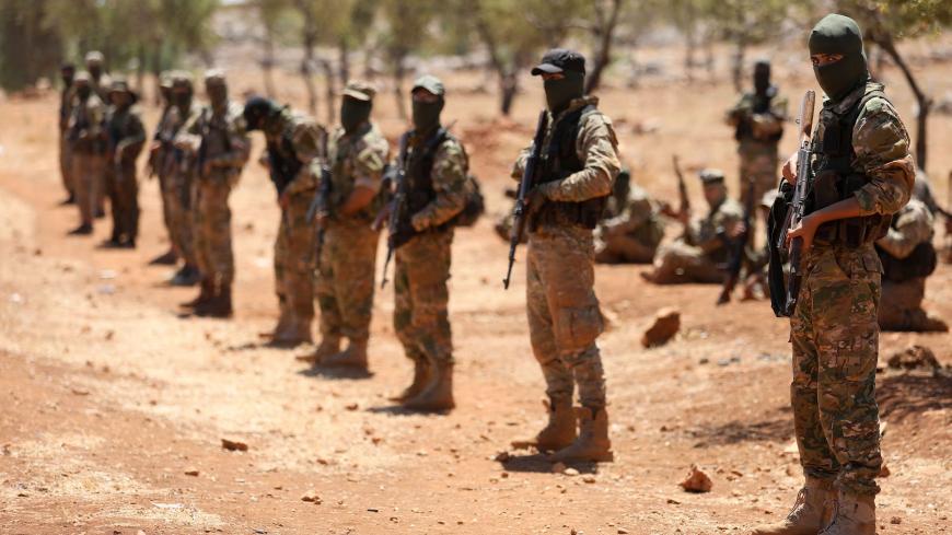 Syrian fighters attend a mock battle in anticipation of an attack by the regime on Idlib province and the surrounding countryside, during a graduation of new Hayat Tahrir al-Sham (HTS) members at a camp in the countryside of the northern Idlib province on August 14, 2018. (Photo by OMAR HAJ KADOUR / AFP)        (Photo credit should read OMAR HAJ KADOUR/AFP via Getty Images)