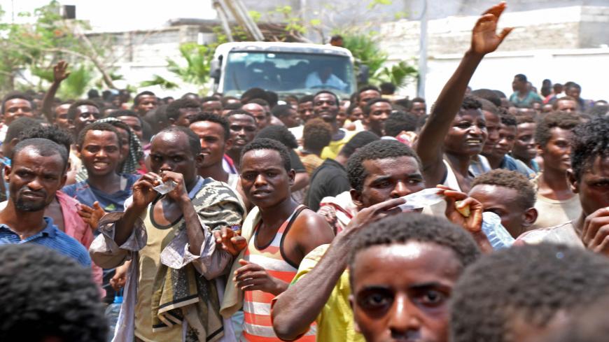 African migrants receive food and water inside a football stadium in the Red Sea port city of Aden in Yemen, on April 23, 2019. - In the southern city of Aden, bastion of the embattled Yemeni government, nearly 2,000 migrants -- mainly from Ethiopia -- have been rounded up by security and are now confined to a soccer stadium which fails to meet basic standards of health and safety, according to the UN migration agency (IOM). (Photo by - / AFP)        (Photo credit should read -/AFP via Getty Images)