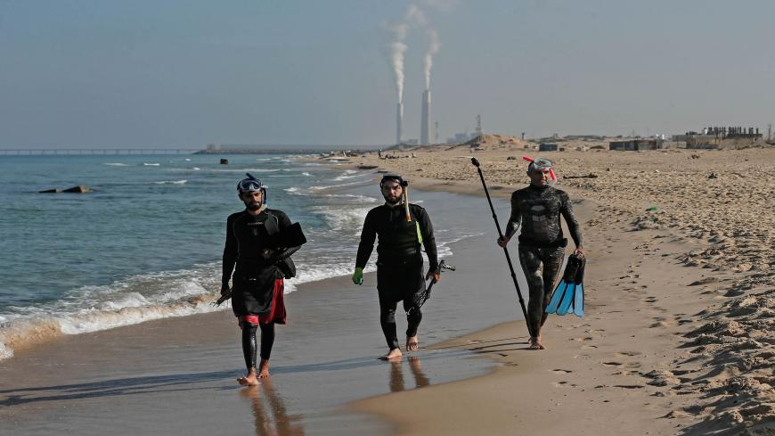 TOPSHOT - Palestinian spear-fishermen prepare to dive with an underwater photographer in the Mediterranean Sea, off the coast of Khan Yunis, in the southern Gaza Strip on October 15, 2020. (Photo by MAHMUD HAMS / AFP) (Photo by MAHMUD HAMS/AFP via Getty Images)