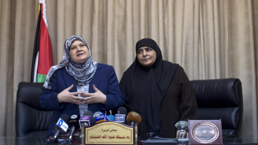 Palestinian Minister of Women's affairs Haifa al-Agha (L) sits next to her predecessor in Gaza Jamila al-Shanti as she attends her first meeting with the new Palestinian government on June 8, 2014 in Gaza city. A unity government sworn in on last week under a reconciliation deal between Hamas and the West Bank-based Palestinian leadership to end seven years of rival administrations in the two territories. AFP PHOTO/MAHMUD HAMS        (Photo credit should read MAHMUD HAMS/AFP via Getty Images)