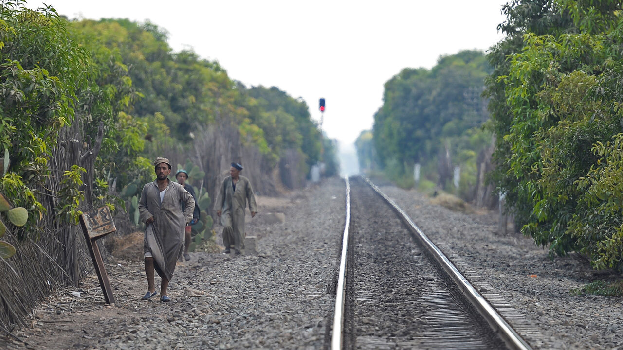 Mango farms workers walk on a railway after the end of their working day in the al-Qata village, Giza Governorate, on August 27, 2018. (Photo by Mohamed el-Shahed / AFP) (Photo credit should read MOHAMED EL-SHAHED/AFP via Getty Images)