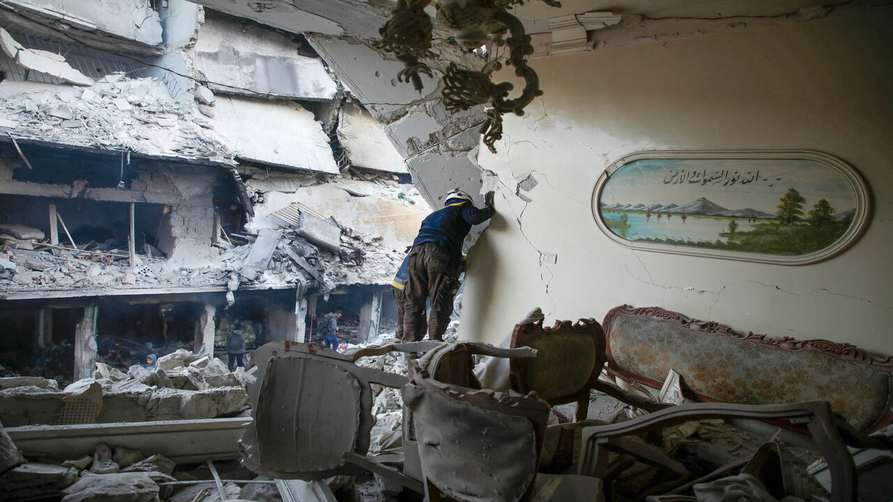 A member of the Syrian Civil Defense, also known as the White Helmets, searches through the rubble and debris in a building at the site of reported airstrikes on the rebel-held town of Ariha in the northern countryside of Idlib province, Syria, Jan. 30, 2020.