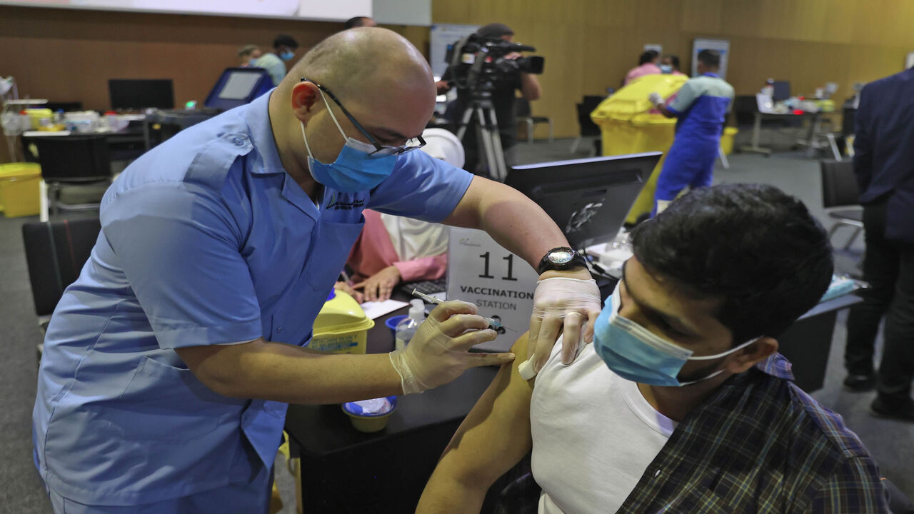 A man receives a dose of the coronavirus vaccine at the Qatar National Convention Center, Doha, Qatar, Feb. 18, 2021.