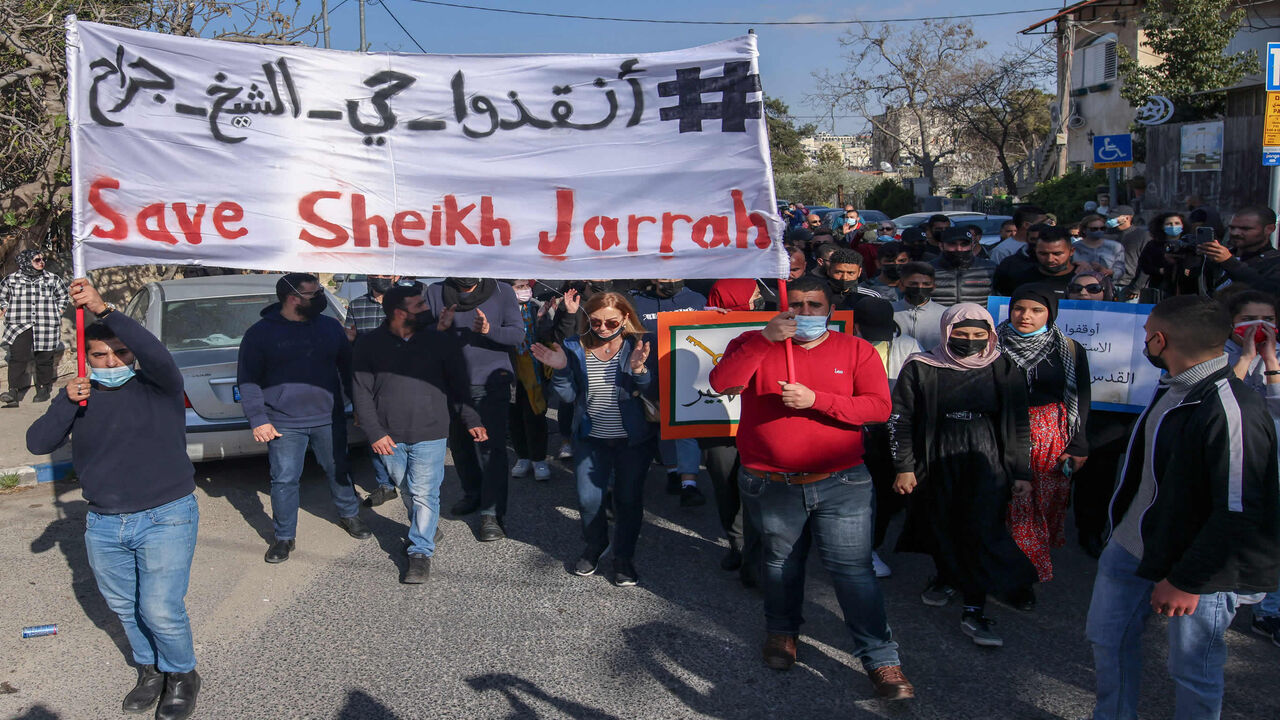 Palestinian, Israeli and foreign activists lift banners and placards during a demonstration against Israeli occupation and settlement activity in the Palestinian territories and East Jerusalem, Sheikh Jarrah neighborhood, Jerusalem, March 19, 2021.