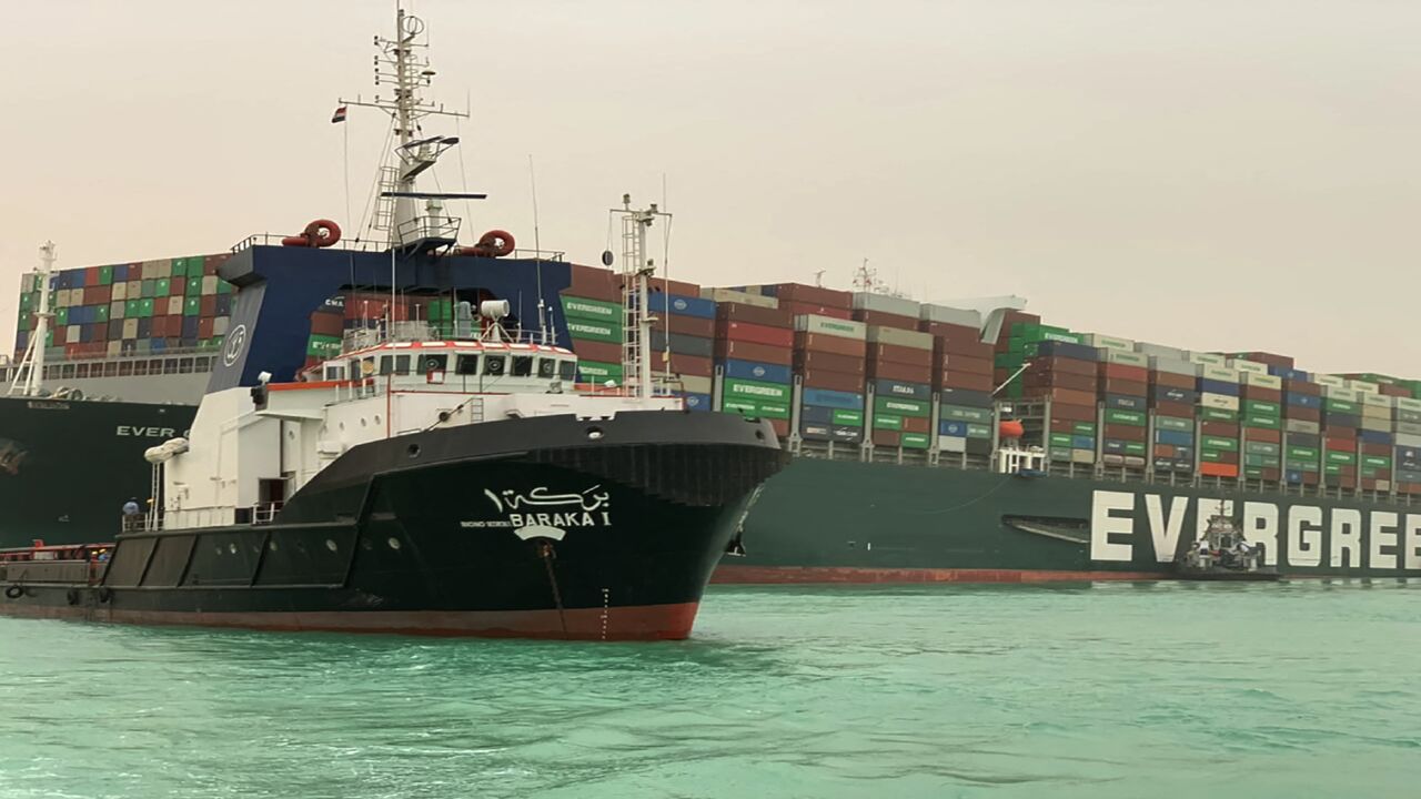 A handout picture released by the Suez Canal Authority on March 24, 2021 shows a part of the Taiwan-owned MV Ever Given (Evergreen), a 400-metre- (1,300-foot-) long and 59-metre wide vessel, lodged sideways and impeding all traffic across the waterway of Egypt's Suez Canal. - A giant container ship ran aground in the Suez Canal after a gust of wind blew it off course, the vessel's operator said on March 24, 2021, bringing marine traffic to a halt along one of the world's busiest trade routes. (Photo by Suez