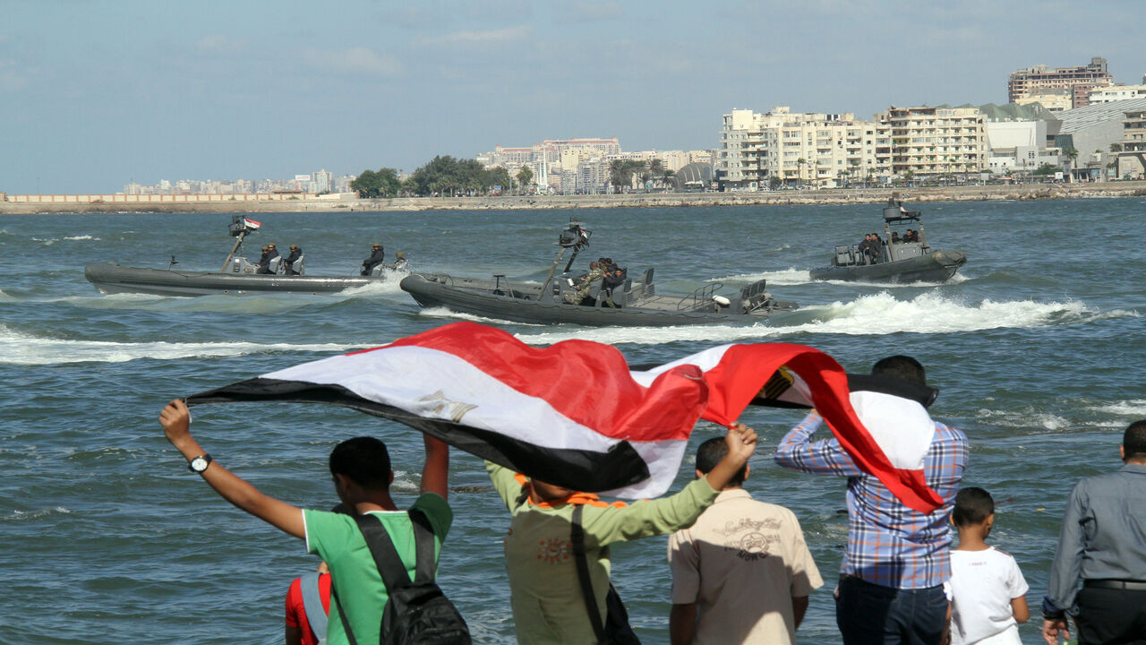 Egyptians celebrates as the navy puts on a display marking the 40th anniversary of the 1973 Arab-Israeli war, along the Mediterranean coastal city of Alexandria, Egypt, Oct. 6, 2013.