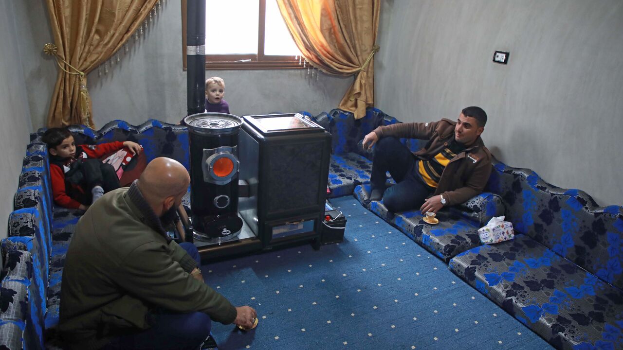 Abu Walid warms his living room with a pistachio-powered heater in Tal al-Karama village, in northwestern province of Idlib, Syria, Dec. 6, 2019.