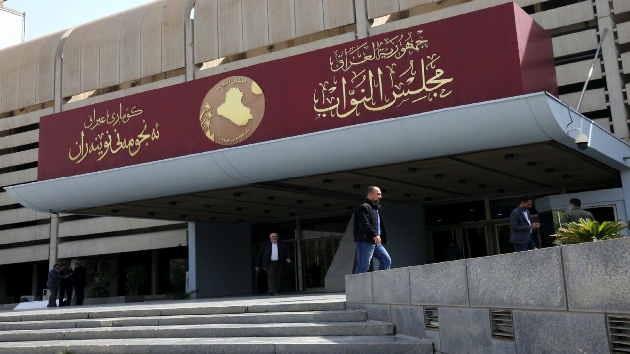 Iraqis stand outside the parliament building, or Council of Representatives, in Baghdad's Green Zone on Feb. 27, 2020. 