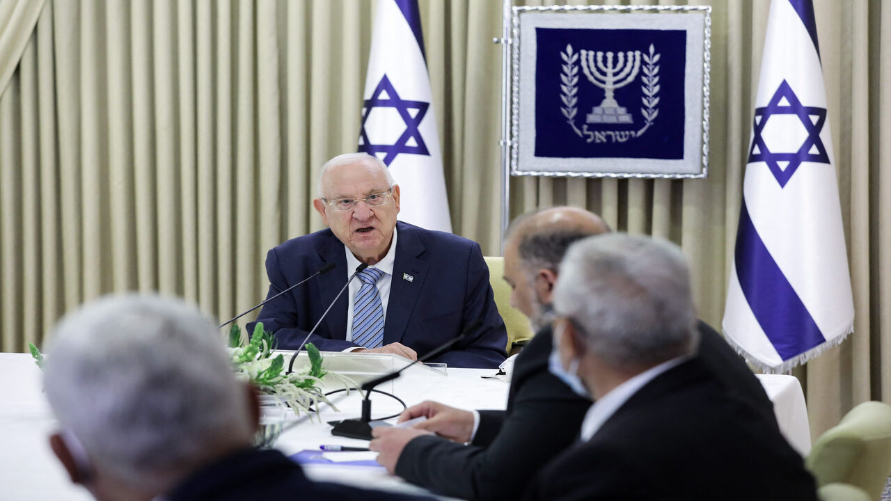 Israeli President Reuven Rivlin (C) speaks with Mansour Abbas, leader of the Arab Joint List, during consultations on who might form the next coalition government, at the president's residence in Jerusalem, April 5, 2021.
