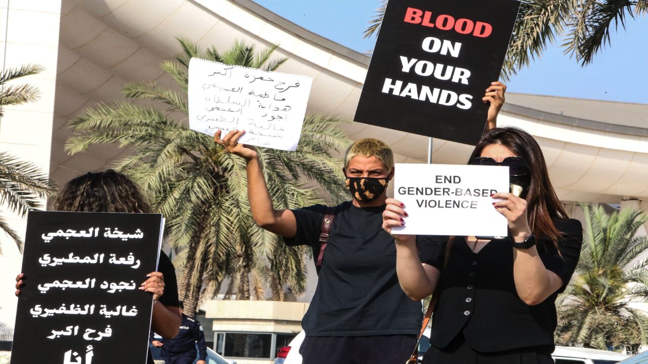 Kuwaiti women raise placards during a rally to denounce violence against women, outside the National Assembly in the capital, Kuwait City, on April 22, 2021. The women demonstrated after Farah Hamaza, a 32-year-old Kuwaiti woman, was recently killed by a young man despite her filing several complaints against him.