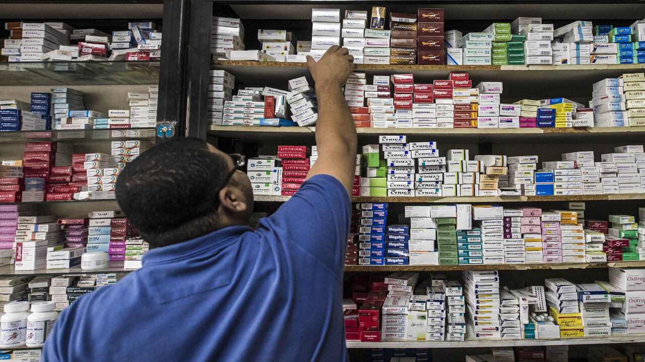 A pharmacy employee reaches out to grab a box of medicine in a pharmacy, Cairo, Egypt, Nov. 9, 2016. 