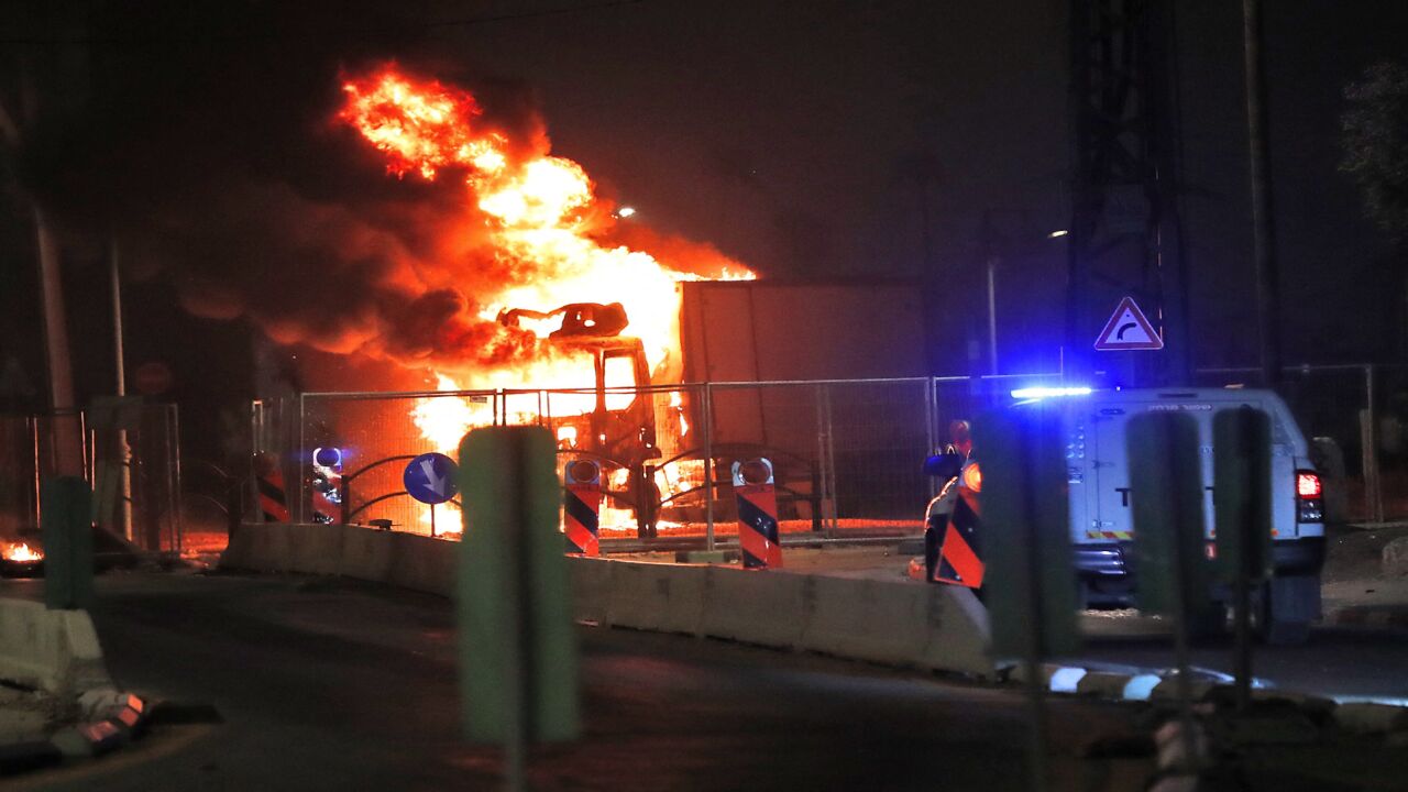 A truck burns at the entrance of the mixed Jewish-Arab city of Lod, where a state of emergency has been declared following civil unrest, on May 12, 2021. Israeli Prime Minister Benjamin Netanyahu declared a state of emergency in Lod, where police said "wide-scale riots erupted among some of the Arab residents," and authorities later imposed an overnight curfew there.