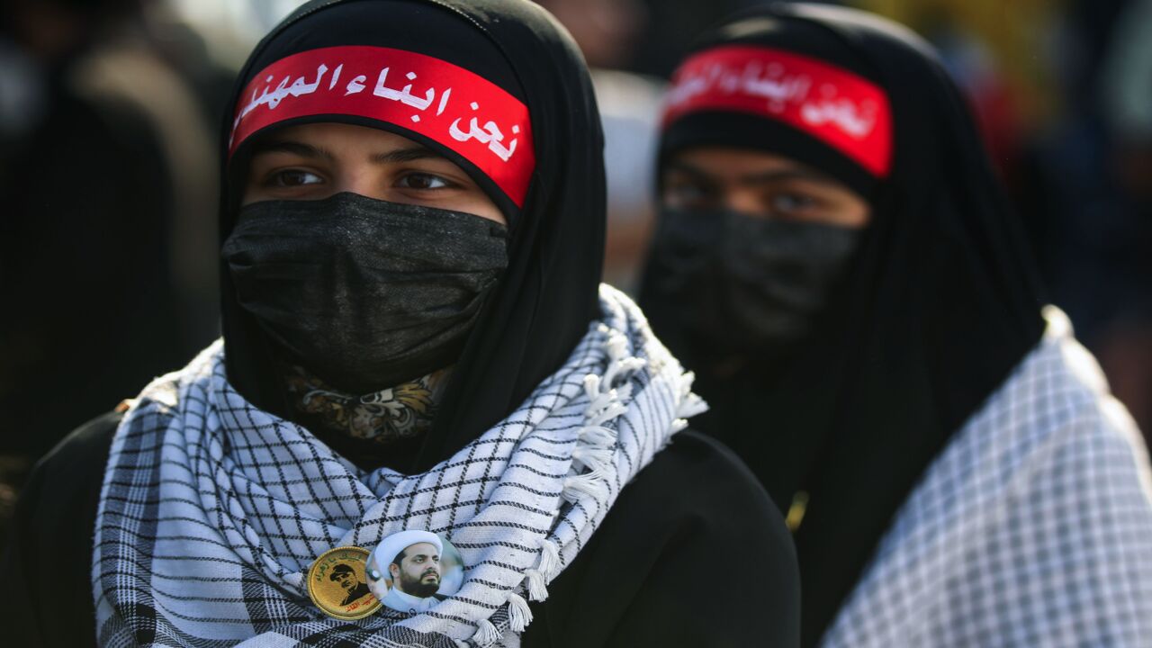 Iraqi girls wearing headbands bearing the slogan "we are the children of (Iraqi commander Abu Mahdi) al-Muhandis" and pins of portraits of Iran's revered commander Qasem Soleimani