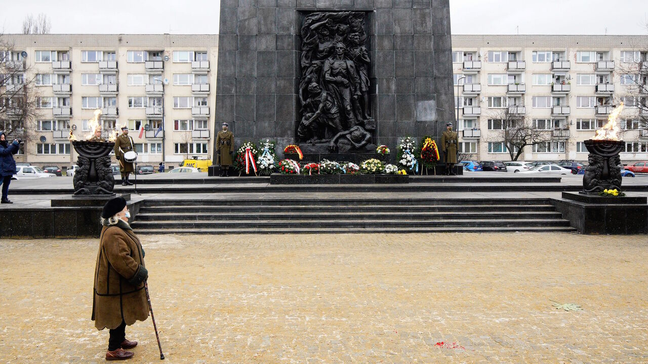 A woman attends a ceremony to commemorate the victims of the Holocaust at the Ghetto Heroes Monument in Warsaw, Poland, on Jan. 27, 2021.