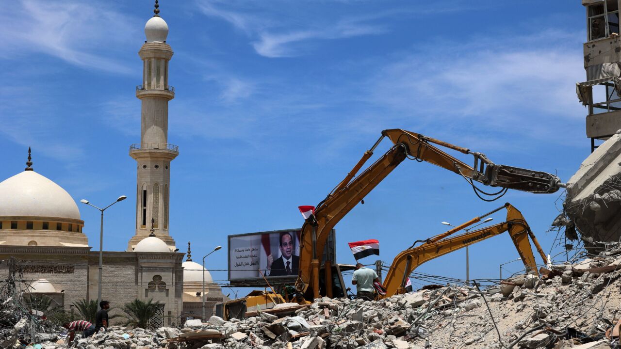 Egyptian workers and bulldozers sent from Egypt help on June 8, 2021, remove the rubble of buildings destroyed by Israeli airstrikes last month in Gaza City.