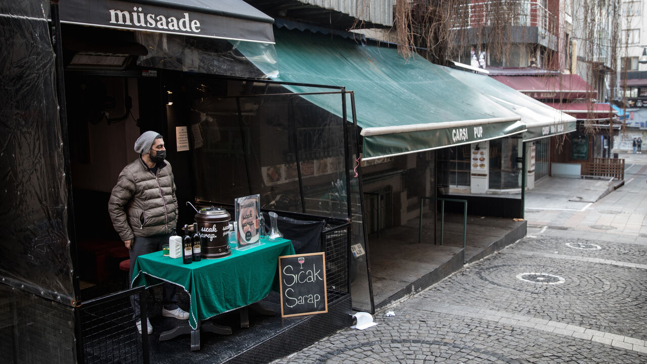 Faruk Ugur waits for customers while selling hot wine at the entrance to his closed restaurant in the Kadikoy district on February 23, 2021 in Istanbul, Turkey.