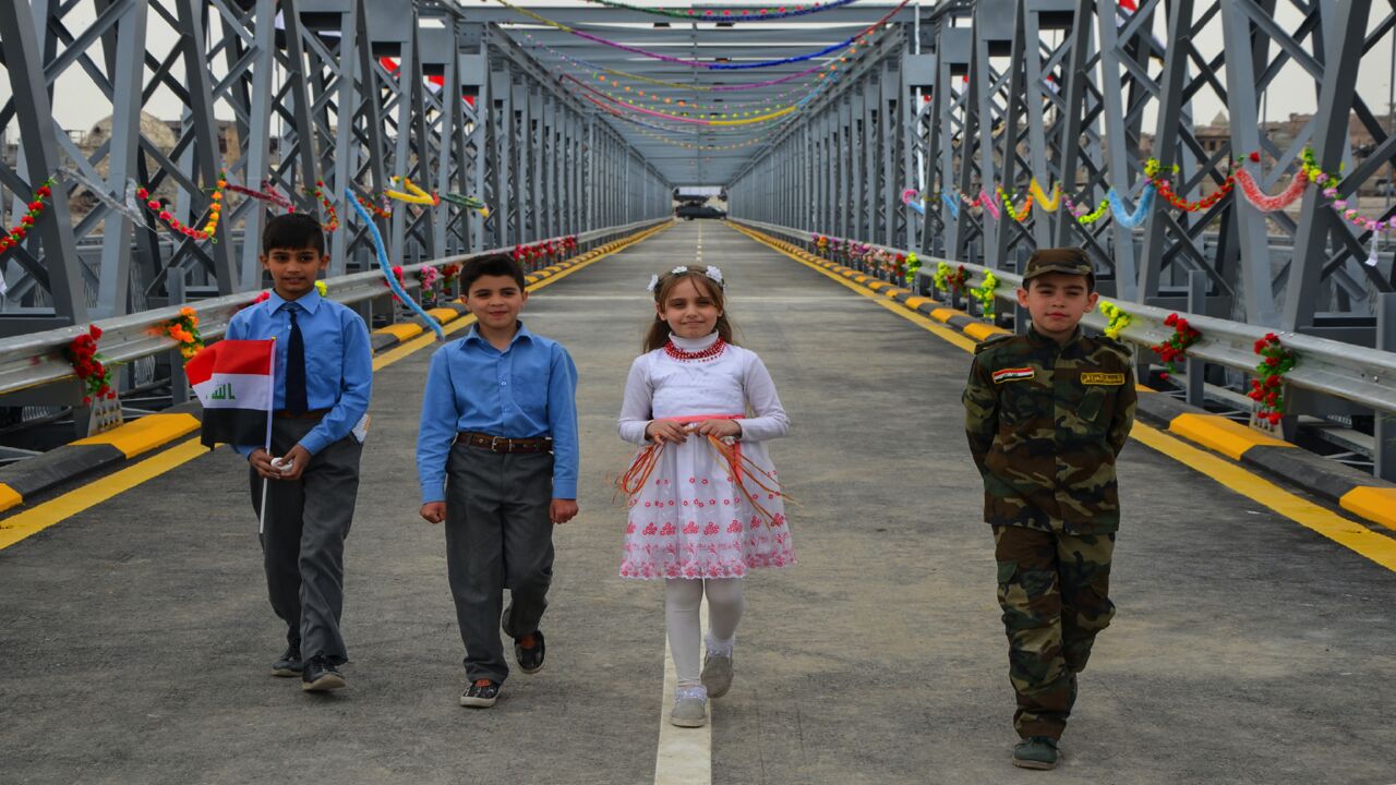 Iraqi children are seen at the Ninevah Bridge, previously known as Mosul's Old Bridge, during an inauguration ceremony following its reconstruction in the city of Mosul on March 14, 2018.