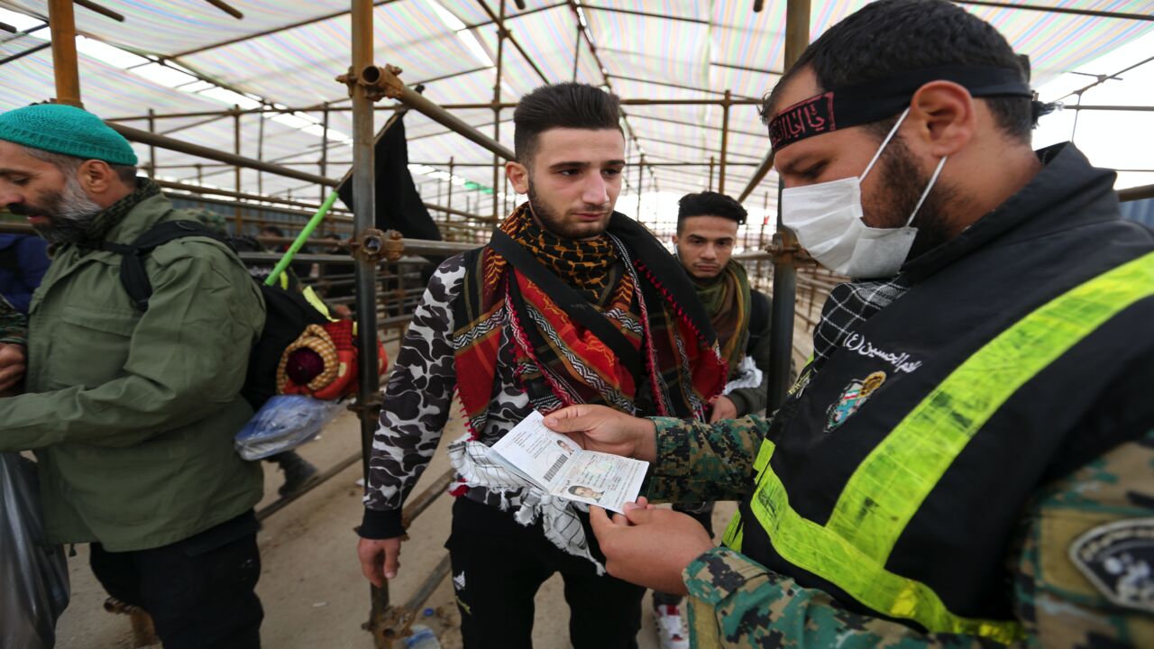 An Iranian policeman checks the travel document of a pilgrim at the Mehran border point between Iran and Iraq.