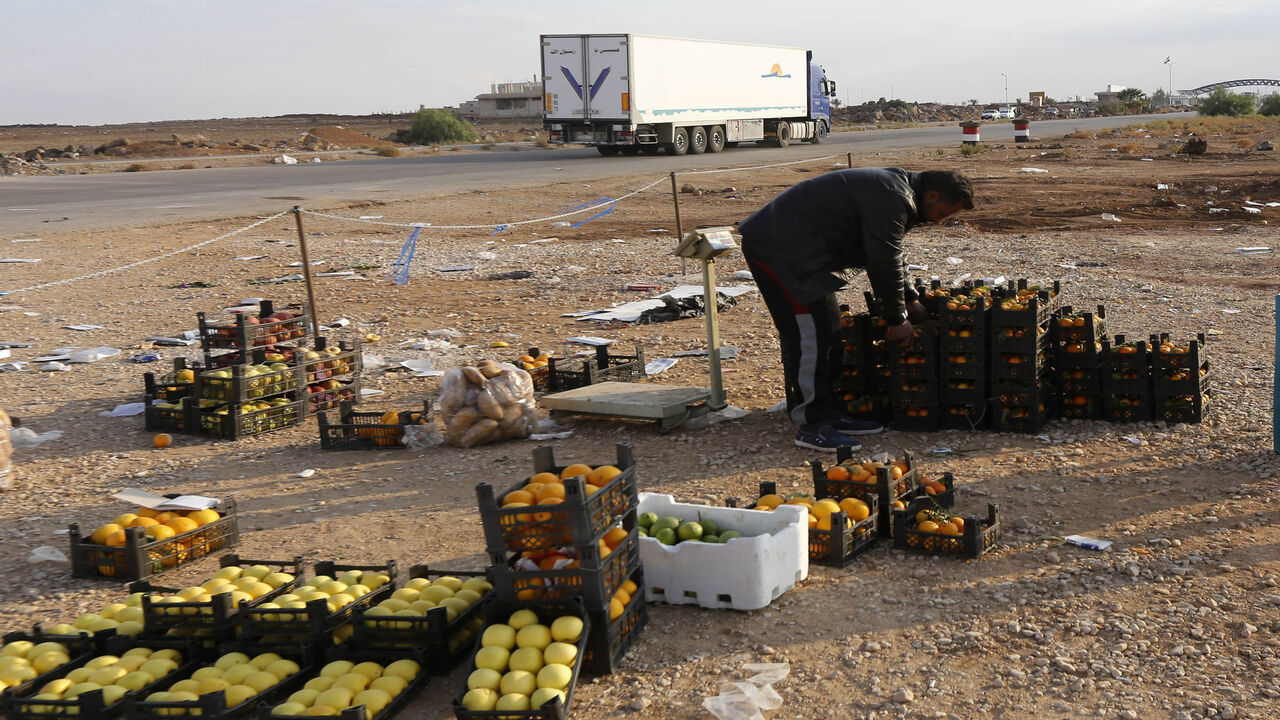 A Syrian vendor sets up his stall of fruits at the recently reopened Nassib border crossing in Daraa province, at the Syrian-Jordanian border south of Damascus, Nov. 7, 2018.