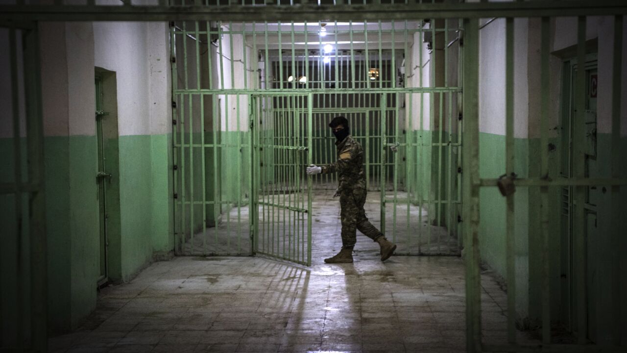 A member of the Syrian Democratic Forces (SDF) stands guard in a prison where men suspected of being affiliated with the Islamic State (IS) group are jailed in northeast Syria in the city of Hasakah on Oct. 26, 2019.