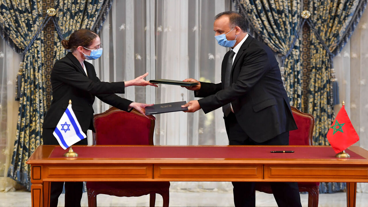 Chief economist at Israel's Ministry of Finance Shira Greenberg (L) and Morocco's Director General of the Customs and Indirect Tax Administration at the Ministry of Economy and Finance Nabil Lakhdar exchange a signed agreement on the first Israel-Morocco direct commercial flight at the Royal Palace, Rabat, Morocco, Dec. 22, 2020.