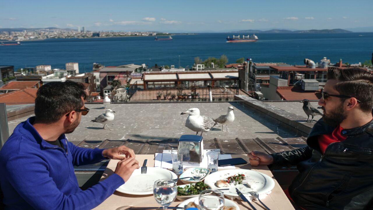 Tourists have a meal at a restaurant at Sultanahmet in Istanbul on May 9, 2021, during a new lockdown aimed at fighting a surging third wave of COVID-19 infections. 