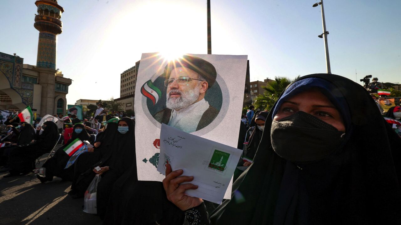 Supporters of Iranian ultraconservative presidential candidate Ebrahim Raisi carry a poster bearing his picture as they attend a rally in the capital, Tehran, on June 16, 2021, ahead of the Islamic Republic's June 18 presidential election. 