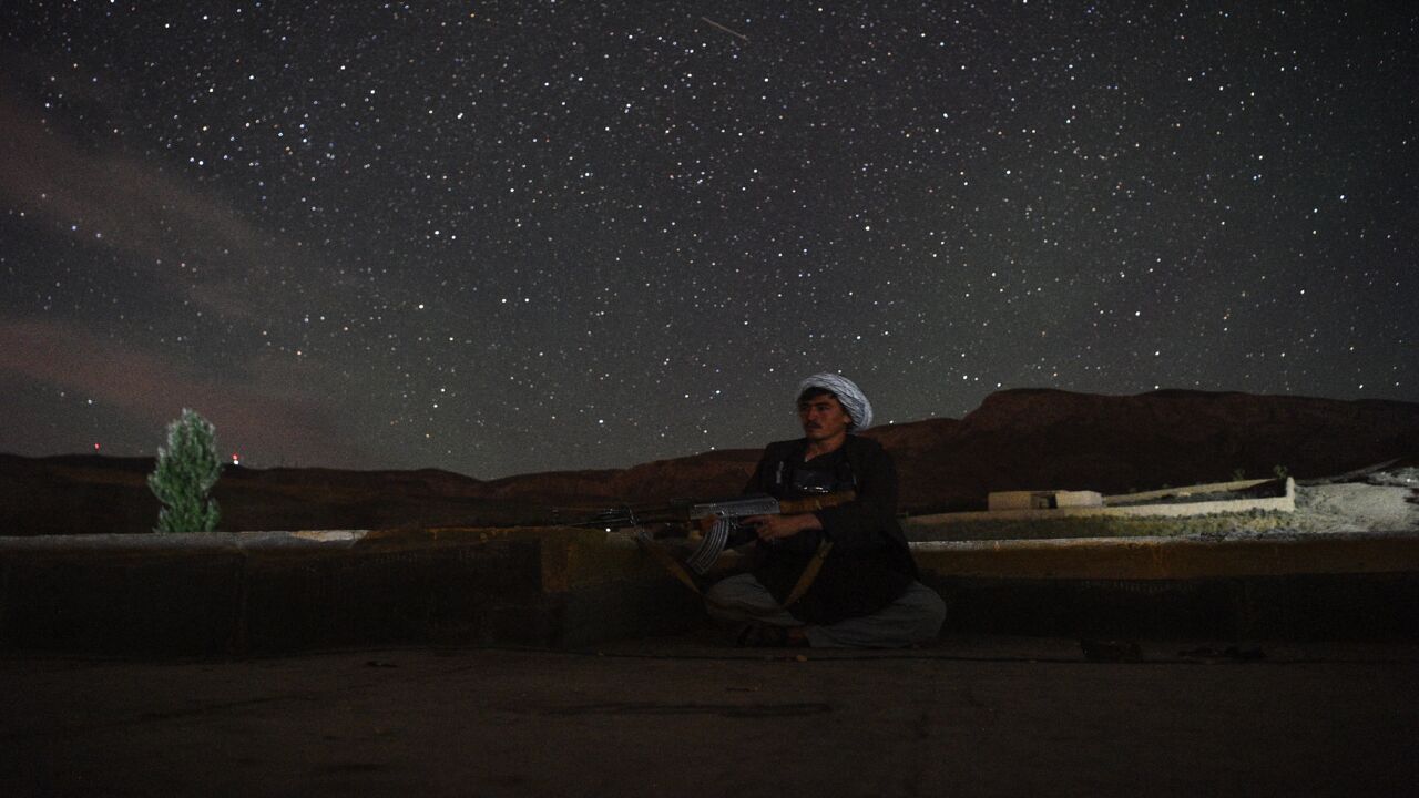 In this picture taken on July 15, 2021, an Afghan militia fighter keeps a watch at an outpost against Taliban insurgents at Charkint district in Balkh Province. 