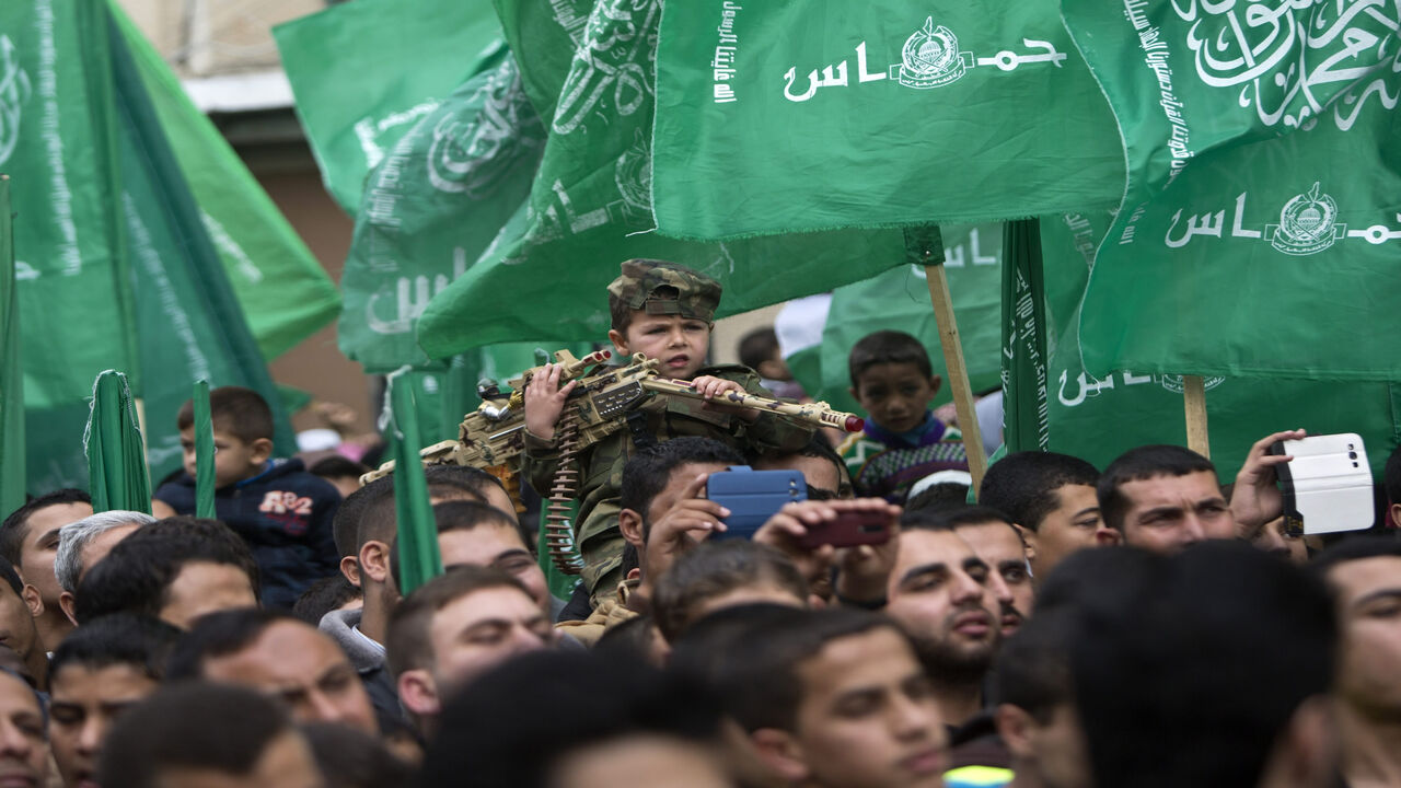 A Palestinian young boy takes part in a rally of Hamas supporters to commemorate the 27th anniversary of the Islamist movement's creation, in Jabaliya refugee camp, Gaza Strip, Dec. 12, 2014.