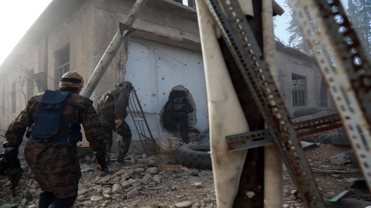 Rebel fighters from the Ahrar al-Sham brigade inspect the interior of a damaged building in the rebel-held besieged town of Harasta, in the eastern Ghouta region on the outskirts of Damascus, Syria, Nov. 16, 2017.