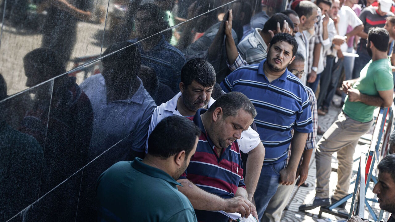 Palestinians stand in line outside the post office to receive Qatari cash aid in Gaza City, Gaza, on Aug. 26, 2019. The aid was the latest in a succession of payments to needy families in the Gaza Strip from Qatar. Israel held up the payments this year in an attempt to ensure that Hamas could not use any of the cash for its military activities; payments now will be directly made into Gazans' bank accounts via the United Nations.