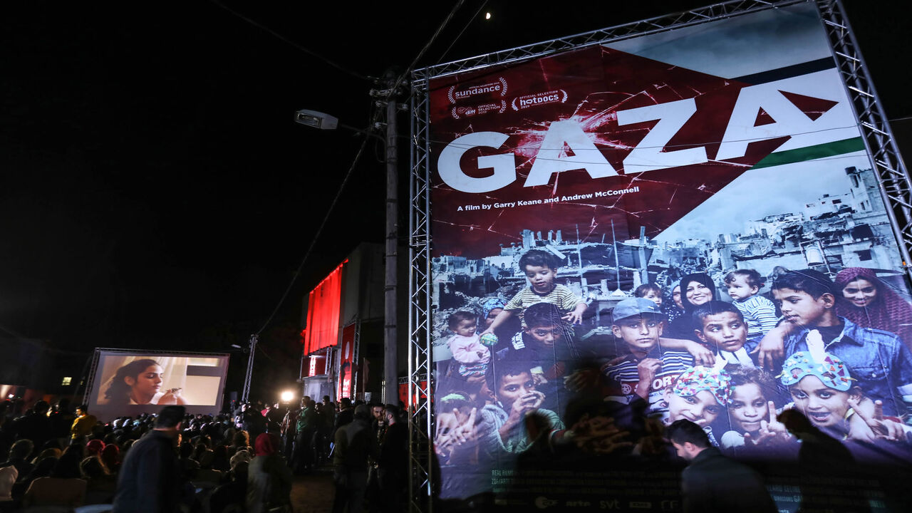 Palestinians watch a film during the opening ceremony of the Red Carpet Human Rights Film Festival in Gaza-Karama Palestine, in front of the abandoned Cinema Amer building in Gaza City, Gaza Strip, Dec. 4, 2019.