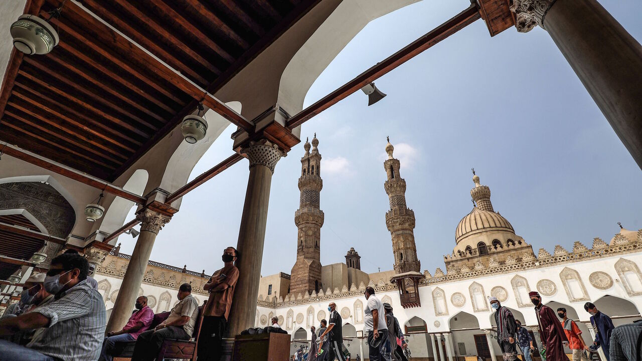Muslim worshippers, mask-clad due to the COVID-19 coronavirus pandemic, arrive at the courtyard of the historic al-Azhar mosque in the centre of Islamic Cairo to perform the Friday prayers under new pandemic restrictions, in Egypt's capital on Aug. 28, 2020.