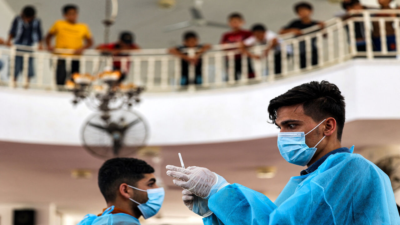 A Palestinian medical worker prepares a dose of Russia's Sputnik V coronavirus vaccine at a mosque in Khan Yunis, Gaza Strip, July 6, 2021.