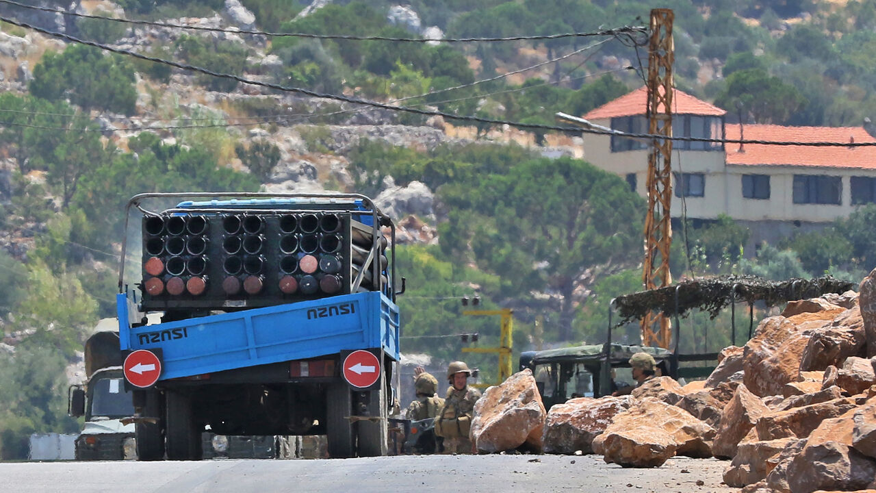 Lebanese soldiers stand next to a truck carrying a multiple rocket launcher after confiscating it