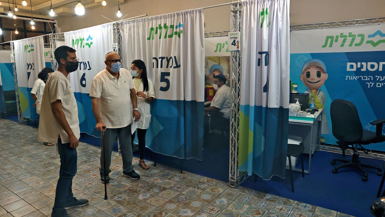 Israelis wait their turn to be inoculated with the Pfizer-BioNTech vaccine against the coronavirus, at a Clalit Health Services station set up inside Cinema City complex in Jerusalem, on Aug. 11, 2021.  