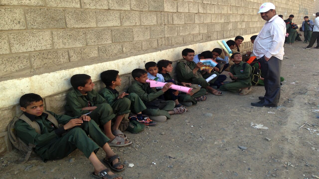 Yemeni school children sit outside their school on Sept. 29, 2014, in the district of Chamlane in northern Sanaa. 